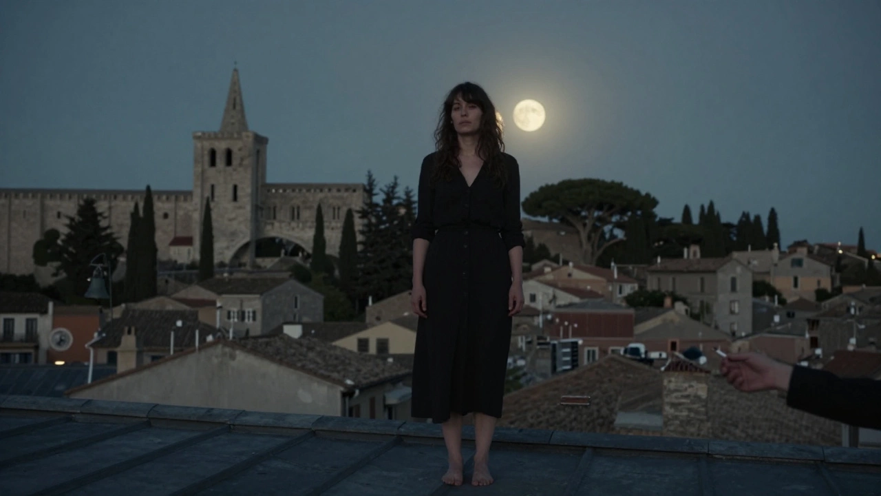 A woman stands barefoot on a rooftop at night, moonlight casting shadows over Avignon’s ancient buildings.